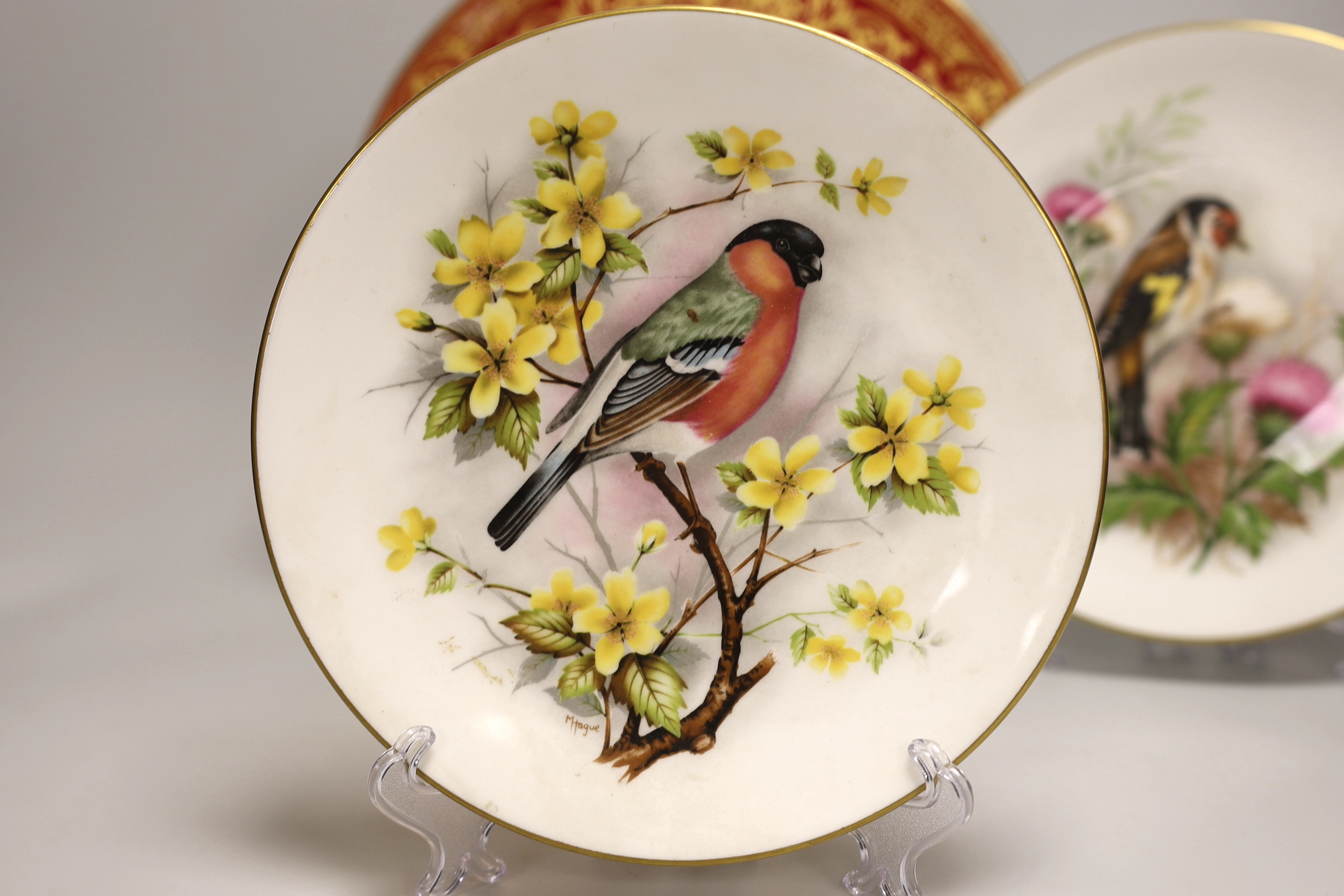 A Royal Worcester fine plate painted with a figure in a tree line landscape by G. Evans, signed and Royal Worcester plates by M Tague, signed with a Bullfinch and a Gold Finch